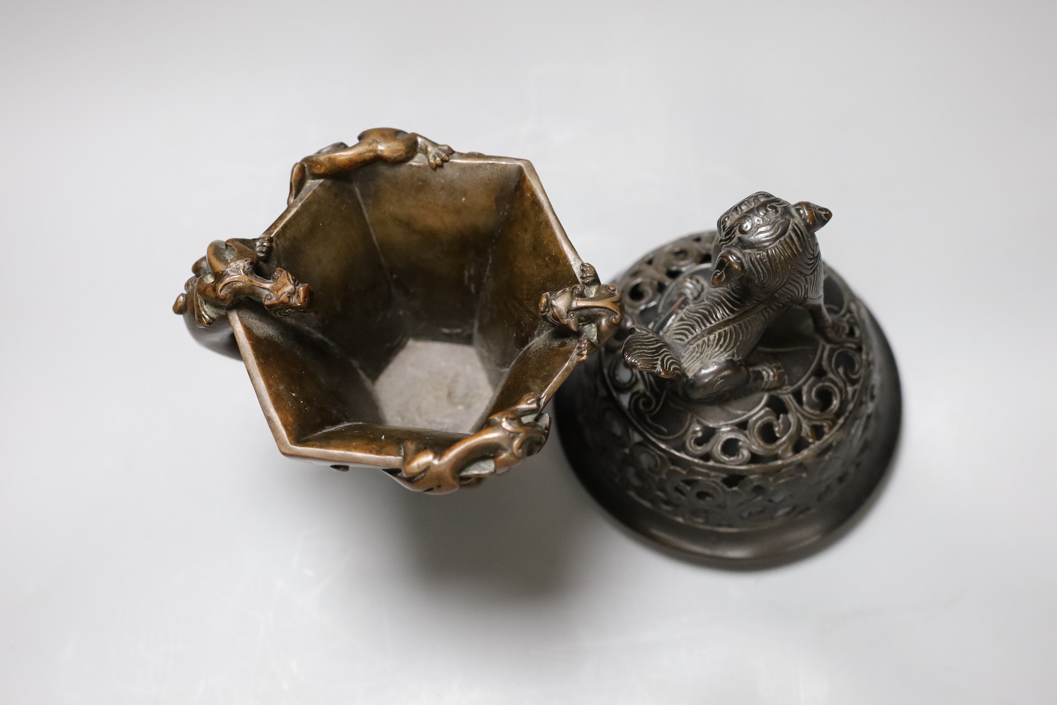 A Chinese bronze handled libation cup, together and a bronze cover with pierced decoration and seated dog, tallest 12cm